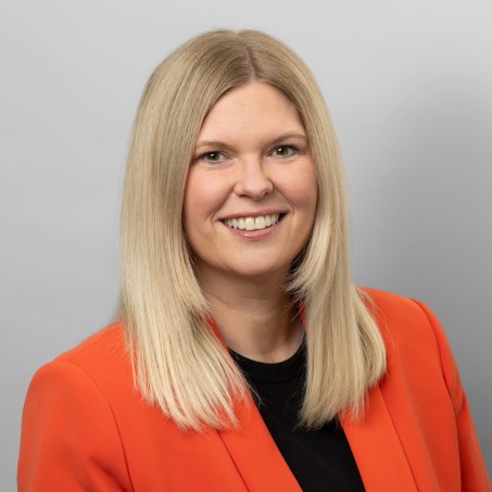 Eine Frau mit blonden Haaren lächelt mich sichtbaren Zähnen in die Kamera.