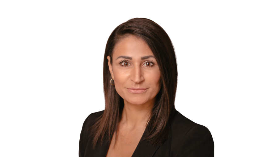 Porträt einer Frau mit dunklem Haar und schwarzer Jacke vor weißem Hintergrund.