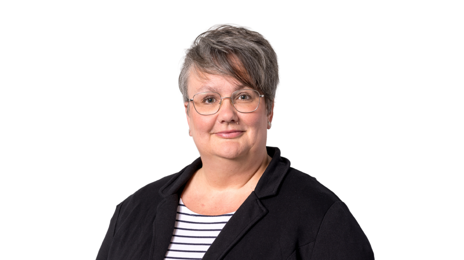 Regionalleitung Katja Röttgen mit Brille und einem dunklen Jakett vor einem hellen Hintergrund